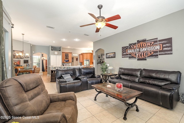 living room featuring ceiling fan with notable chandelier and light tile patterned floors