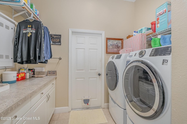 clothes washing area featuring washing machine and dryer and light tile patterned floors