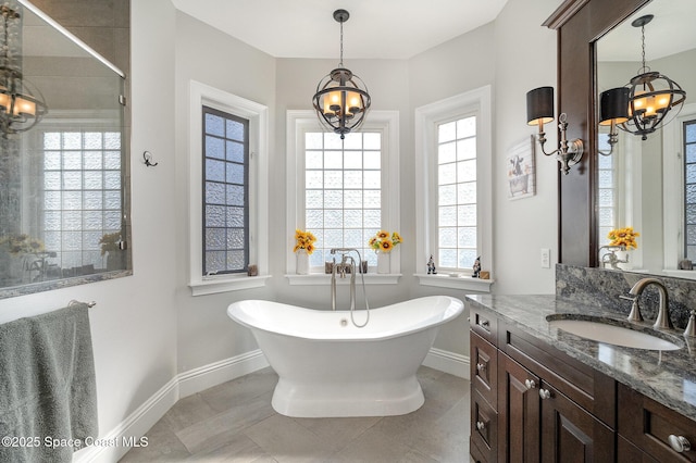 bathroom featuring vanity, a bath, tile patterned floors, and a chandelier