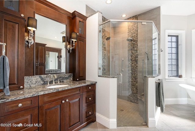 bathroom featuring a shower with door, vanity, and tile patterned flooring