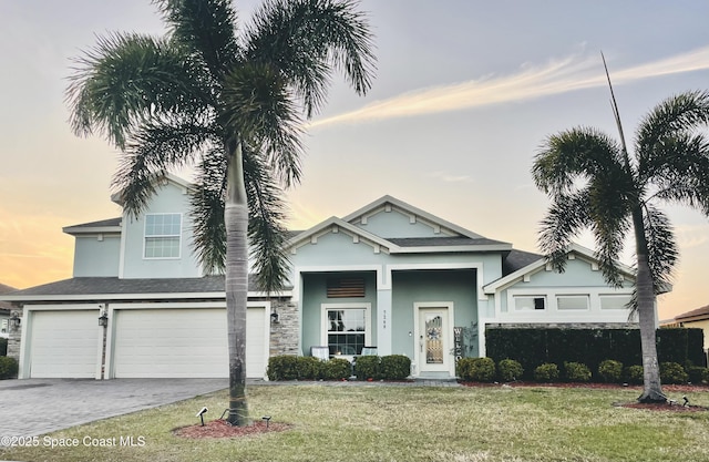 view of front of home featuring a garage and a lawn