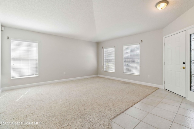 carpeted entryway featuring a textured ceiling