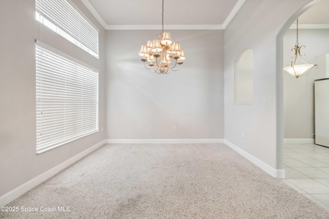 tiled spare room with crown molding and a chandelier