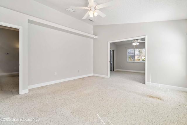 empty room with a textured ceiling, vaulted ceiling, and ceiling fan