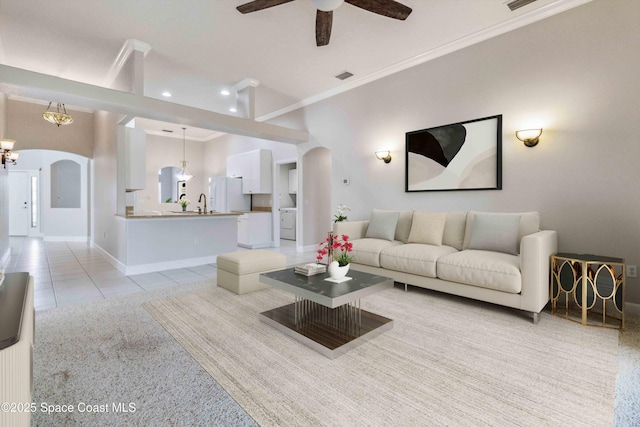 tiled living room featuring crown molding, ceiling fan, and sink