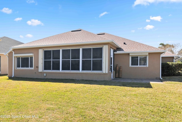 rear view of house featuring a lawn