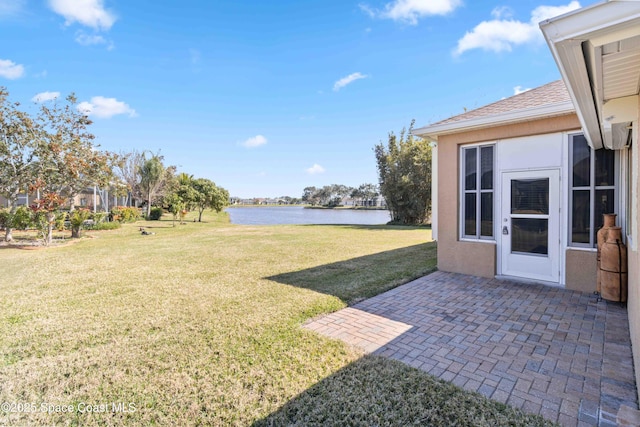 view of yard with a water view and a patio