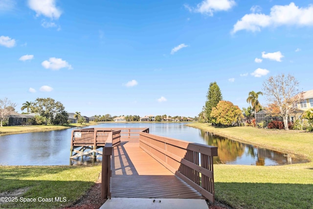 dock area with a water view and a yard