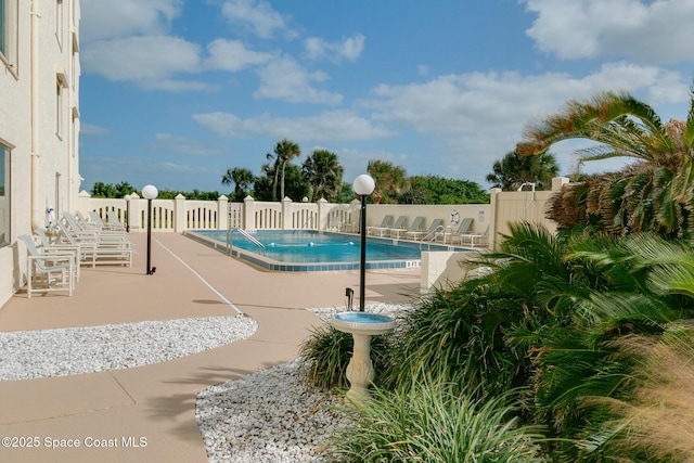 pool with fence and a patio