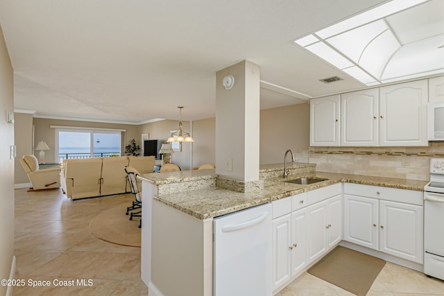 kitchen with a peninsula, white appliances, visible vents, white cabinets, and light stone countertops