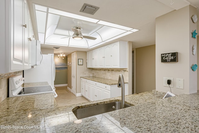 kitchen featuring white electric stove, light countertops, visible vents, white cabinetry, and a sink