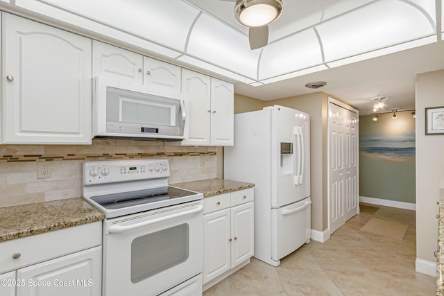 kitchen with white appliances, tasteful backsplash, baseboards, light stone counters, and white cabinetry