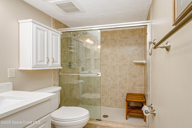 bathroom with toilet, a stall shower, visible vents, and vanity