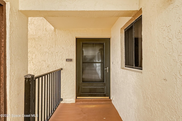 doorway to property featuring stucco siding