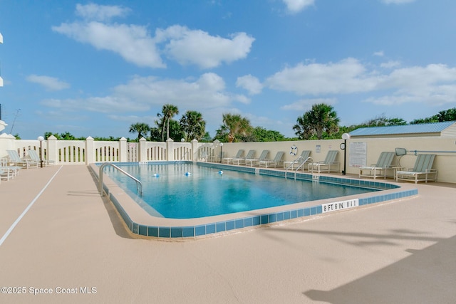 pool featuring fence and a patio