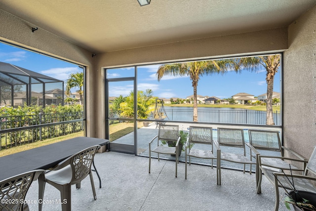 sunroom featuring a water view