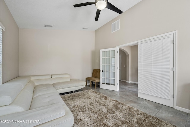 living room with a towering ceiling and ceiling fan