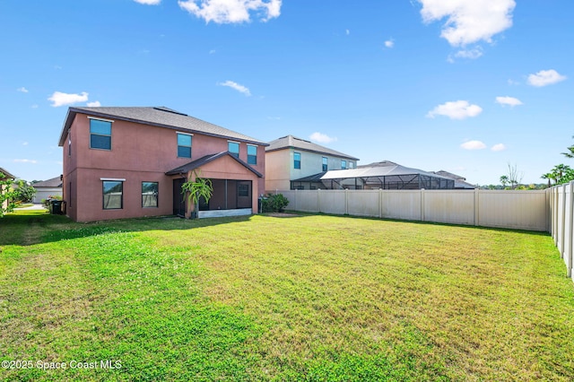 back of property with a yard and a sunroom