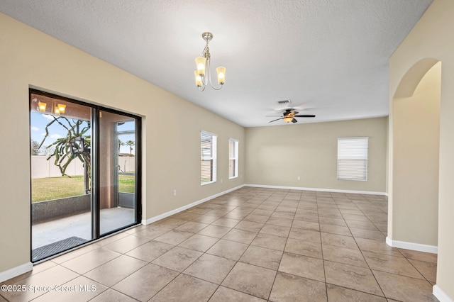 spare room with ceiling fan with notable chandelier, a textured ceiling, and light tile patterned flooring