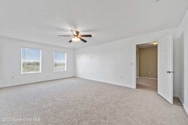 unfurnished room featuring ceiling fan, light colored carpet, and a textured ceiling