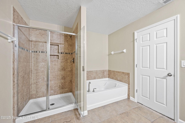 bathroom with tile patterned floors, plus walk in shower, and a textured ceiling