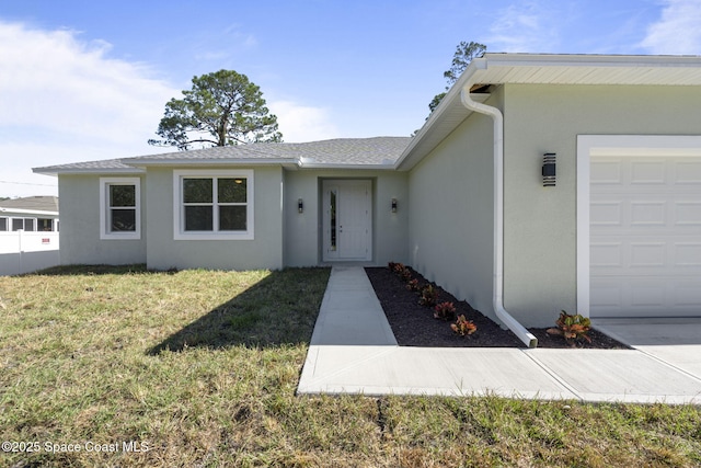 view of front of property featuring a garage and a front lawn