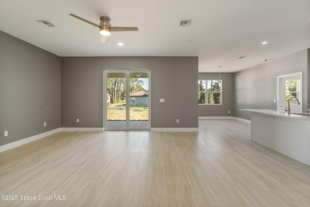 spare room featuring sink, ceiling fan, and light wood-type flooring