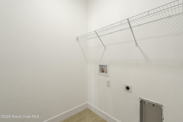 laundry area featuring electric dryer hookup, hookup for a washing machine, and hardwood / wood-style flooring