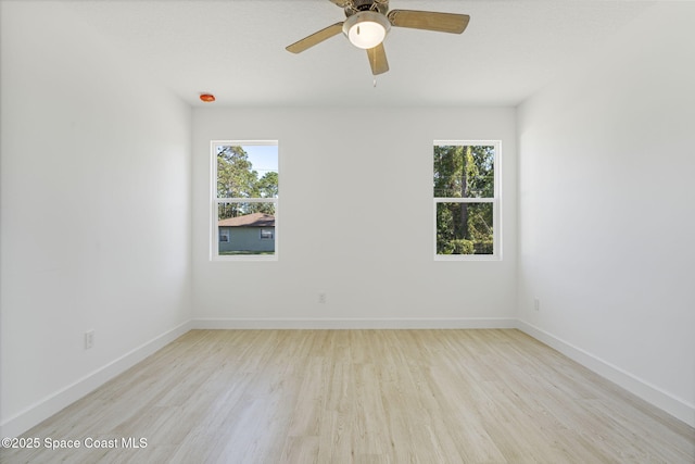 empty room featuring ceiling fan, plenty of natural light, and light hardwood / wood-style floors