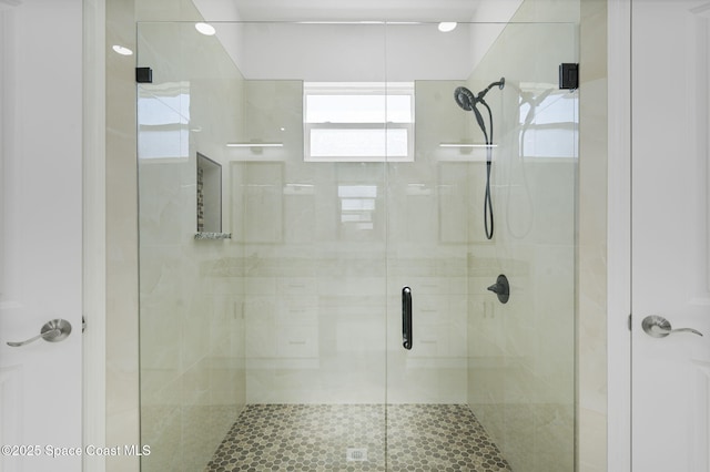 bathroom with a shower with door