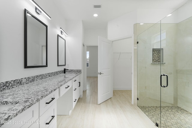 bathroom featuring vanity, a shower with door, and hardwood / wood-style floors