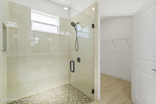 bathroom featuring hardwood / wood-style floors and a shower with shower door