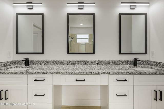 bathroom with walk in shower and vanity