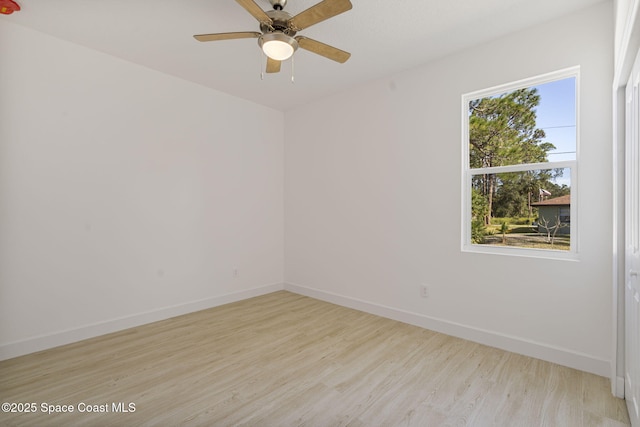 empty room with ceiling fan and light hardwood / wood-style flooring