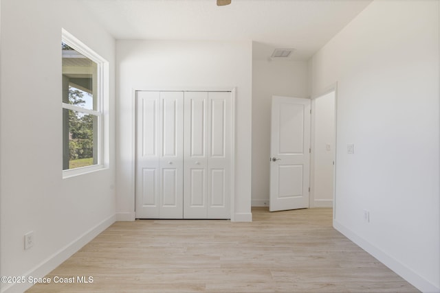 unfurnished bedroom with a closet and light wood-type flooring