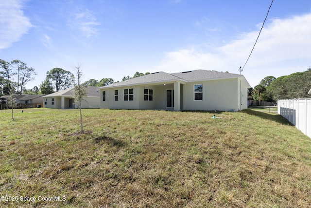 rear view of house featuring a yard