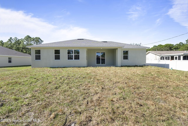 rear view of property featuring a yard