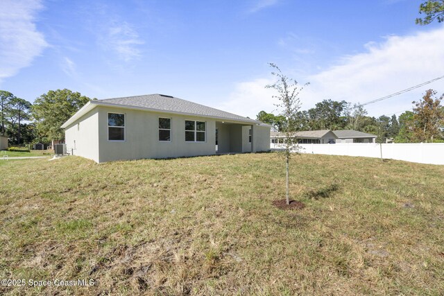 view of front of house featuring central AC unit and a front yard