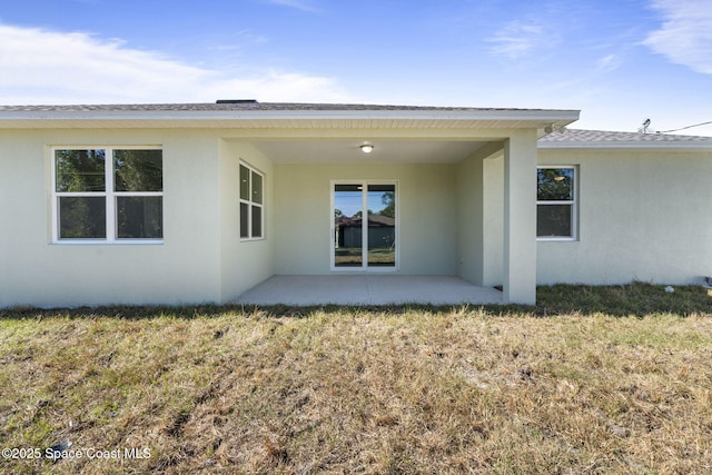 rear view of property featuring a lawn and a patio