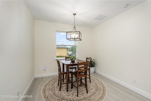 dining area featuring an inviting chandelier and light hardwood / wood-style flooring