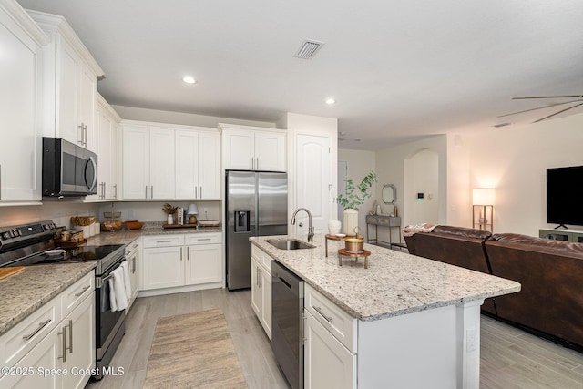 kitchen featuring sink, stainless steel appliances, light stone countertops, a kitchen island with sink, and white cabinets