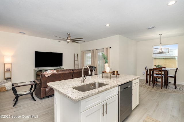 kitchen with sink, a center island with sink, hanging light fixtures, dishwasher, and white cabinets