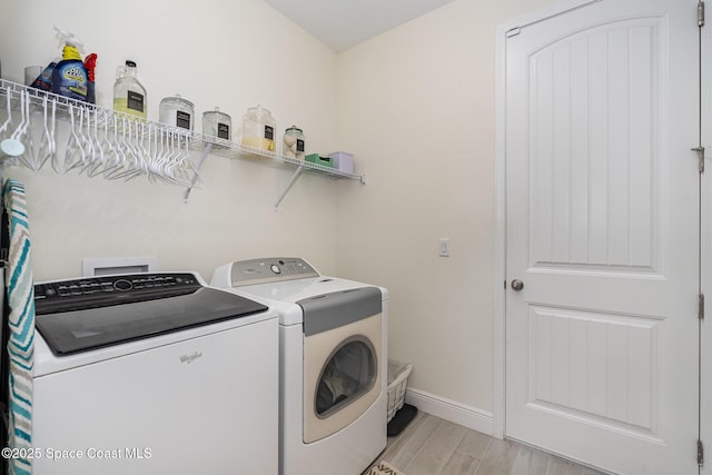 laundry room featuring washing machine and dryer and light wood-type flooring