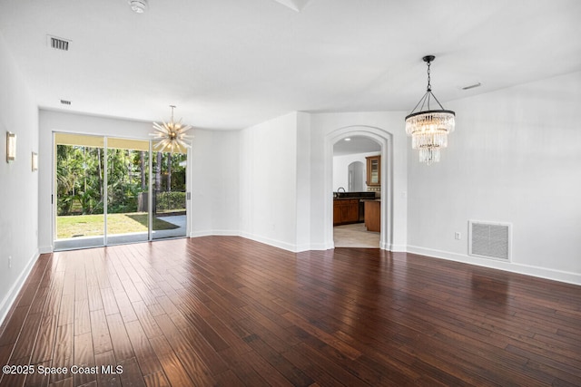 spare room with sink, a chandelier, and hardwood / wood-style floors