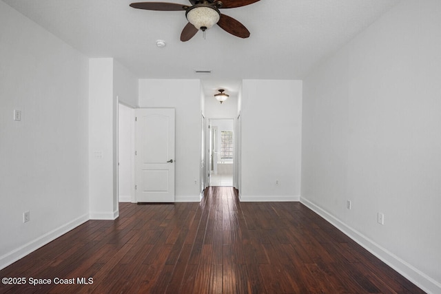 empty room with dark wood-type flooring and ceiling fan