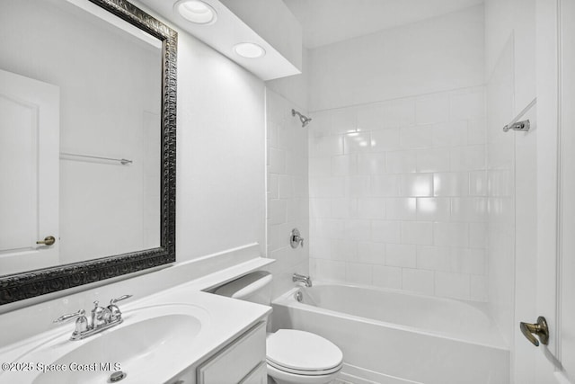 full bathroom with vanity, tiled shower / bath combo, and toilet