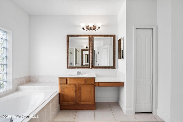 bathroom featuring vanity, a relaxing tiled tub, and tile patterned floors