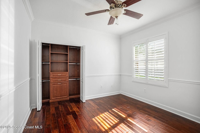 unfurnished bedroom featuring ornamental molding, ceiling fan, dark hardwood / wood-style flooring, and a closet