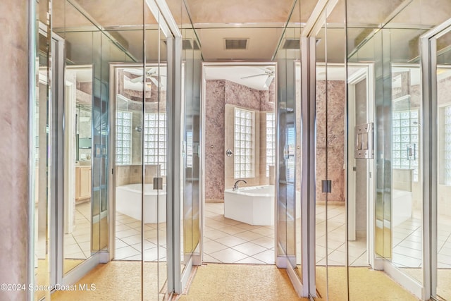 bathroom with tile patterned floors, tile walls, and a washtub