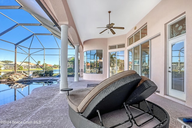 view of patio with ceiling fan and glass enclosure